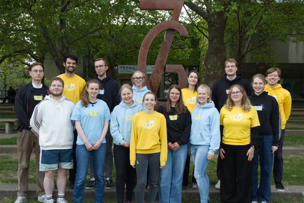 Ein Gruppenbild des GöHört-Teams des Sommersemesters 2025 vor dem Denkmal am Platz der Göttinger Sieben in Göttingen.